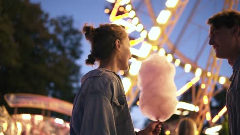 Young-Couple-Dating,-Meeting-At-The-Amusement-Park,-Male-Bring-A-Cotton-Candy-To-Her-Girlfriend