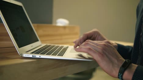 Männliche-Hände,-Die-Etwas-Auf-Der-Laptop-tastatur-Eingeben-Und-Webseiten-Scrollen