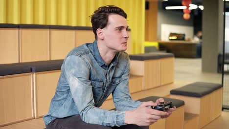Attractive-Sexy-Young-Guy-In-Denim-Shirt-Playing-Video-Games-With-Sincere-Excitement