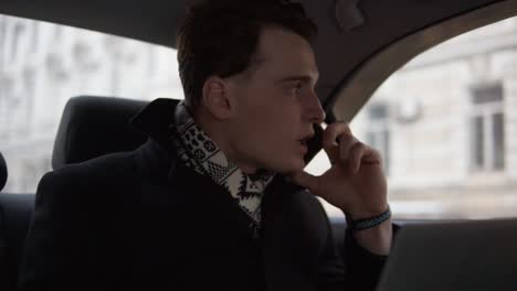 Attractive-Young-Guy-Is-Arguing-With-Someone-On-The-Phone-While-Riding-In-A-Car