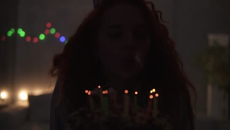 Portrait-Of-A-Smiling-Curly-Red-Haired-Girl-Making-A-Wish-And-Blowing-Candles-Out-On-Her-Birthday-Cake
