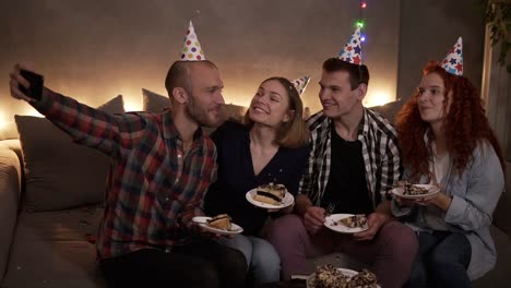 Cheerful,-Young-Friends-Or-Two-Couples-Having-Small,-Cozy-Birthday-Celebration,-Sitting-Together-In-Festive-Cones-On-The-Couch-And-Taking-Selfie-Using-A-Mobile-Phone