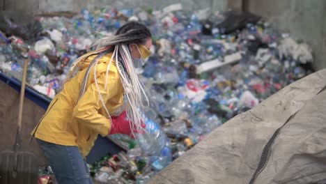 Woman-Worker-In-Yellow-Jacket-And-Transparent-Protecting-Glasses-Sorting-Used-Plastic-Bottles-At-Modern-Recycling-Plant