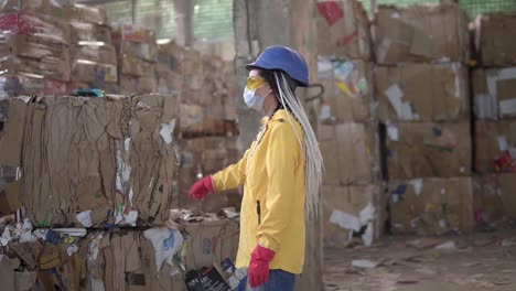 Unloading-Of-Waste-Paper-In-A-Warehouse-Electric-Car-Controling-By-Female-Worker-In-Hard-Hat-And-Yellow-Jacket
