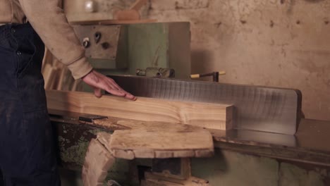 Close-Up-Footage-Of-Man-In-Work-Clothes-Working-On-Electric-Saw-With-Wooden-Material-In-Carpentry