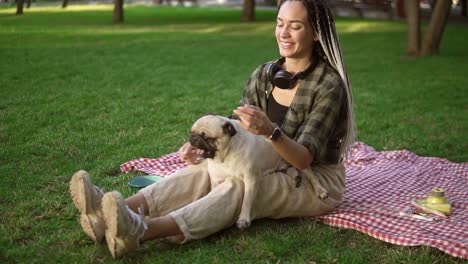 Attractive-Woman-Holds-A-Little-Pug-On-Her-Knees-It-Actively-Whirls-And-Tries-To-Bite-Gently