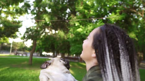 Dreadlocks-Woman-Happily-Throws-The-Dog-In-The-Air-In-The-Park