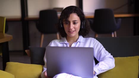 Portrait-Of-Curly,-Brunette-Woman-Working-On-Laptop-At-Home-Office