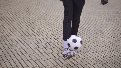 Ein-Junger-Mann-Wirft-Einen-Fußball-Mit-Den-Füßen