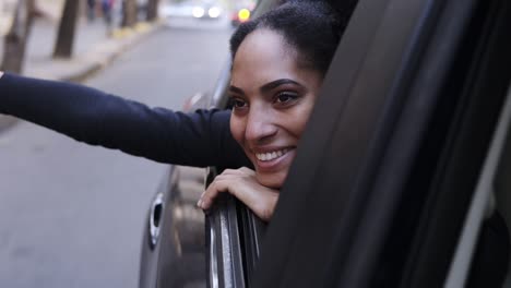 Curious-Excited-Young-Afro-Woman-Looks-Around-At-The-Beautiful-City-Sights-Out-Passenger-Side-Window