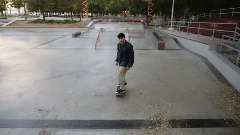 Active-Man-Doing-Skateboard-Trick-On-Edge-Of-Skateboard-Ramp-At-Skateboard-Court,-Stops-On-The-Top