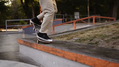 Unrecognizable-Skateboarder-Jumping-And-Sliding-On-Concrete-Bench-On-Street-Or-Skatepark