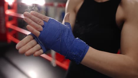 Woman-Rubs-Powder-On-Her-Hands-Wrapped-In-Boxing-Tapes-On-Boxing-Ring