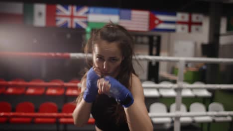 Active-Female-Boxer-Punching-Camera-During-Training-In-Bandages