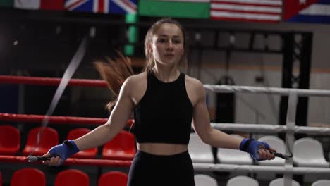 Young-Woman-In-A-Black-Sports-Top-With-A-Skipping-Rope-In-A-Boxing-Gym-In-The-Ring