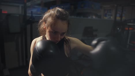 Female-Boxer-Shaking-Camera-During-Training-In-Gloves-With-Bag