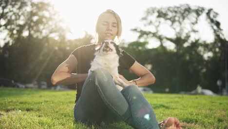 Young-Beautiful-Girl-Sitting-On-The-Grass-With-Her-Dog