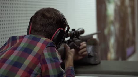 Close-Up-Of-A-Man-Shooting-Use-Rifle-At-Shooting-Range-In-Headphones