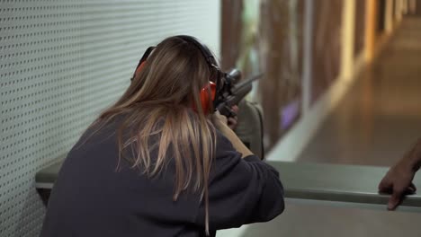 Woman-With-Pneumatic-Rifle-In-Hands-At-Shooting-Range-With-Target,-Excited-And-Surprised-By-Shot