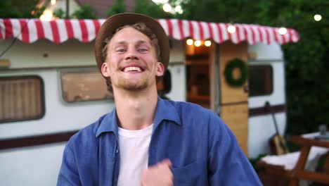 Portrait-Of-Toothy-Smiling-Man-In-Casual-Clothes-And-Summer-Hat-Is-Dancing-Outdoors-In-Front-The-Trailer-Truck