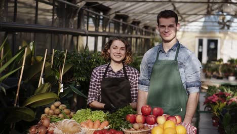 Portrait-Of-Beautiful-Farmers-Man-And-Woman-In-Aprons-Selling-Organic-Food-In-Farm-Market