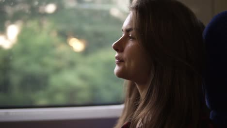 Pensive-Woman-Relaxing-And-Looking-Out-Of-A-Train-Window