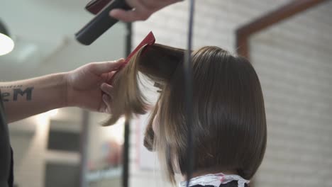 Close-Up-Shot-Of-A-Woman-Having-Her-Hair-Straightened-In-Hair-Salon