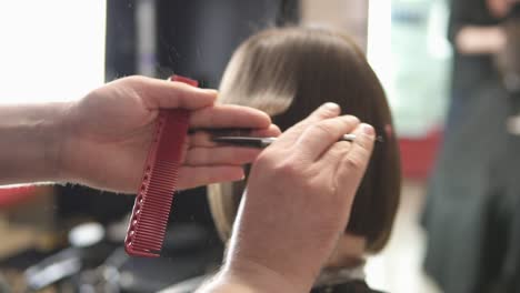 Closeup-View-Of-A-Hairdresser's-Hands-Cutting-Hair-With-Scissors-1