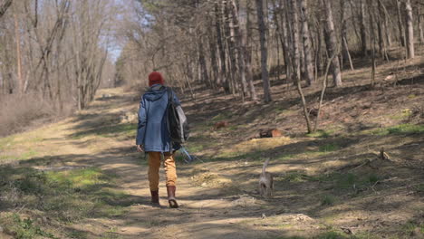 An-Unrecognizable-Young-Woman-Takes-A-Walk-With-Her-Dog-In-The-Forest