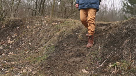 The-Boots-Of-An-Unrecognizable-Person-Walking-Down-A-Slope-In-The-Countryside