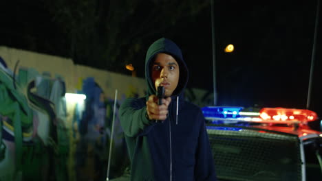 Portrait-Shot-Of-Young-Moulatto-Male-Criminal-In-Hood-Looking-Straight-And-Pointing-Gun-At-Camera