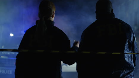 Rear-Of-The-Mixed-Races-Man-And-Woman-From-Fbi-Going-At-Night-Street-To-Crime-Scene