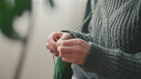The-Hands-Of-An-Unrecognizable-Woman-Knitting-With-Green-Wool-1