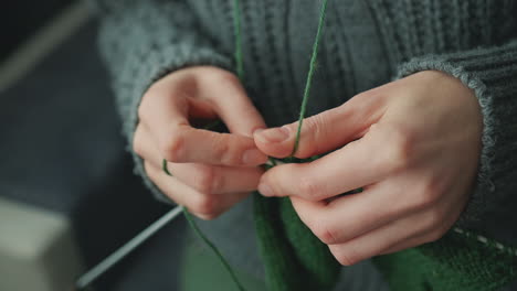 The-Hands-Of-An-Unrecognizable-Woman-Knitting-With-Green-Wool-3