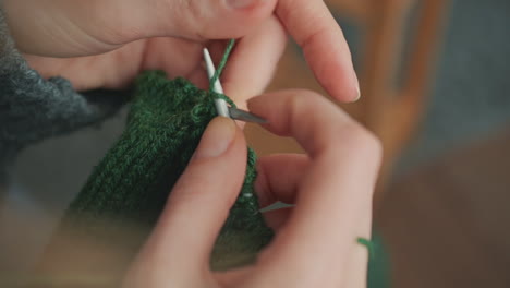 The-Hands-Of-An-Unrecognizable-Woman-Knitting-With-Green-Wool-4
