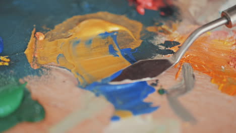 Detail-Of-A-Spatula-Mixing-Colors-On-A-Painter's-Palette