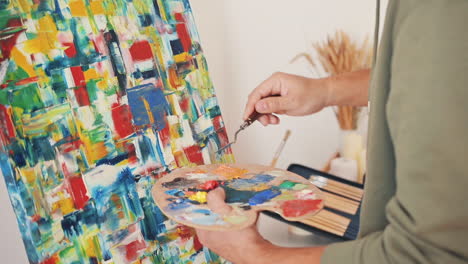 The-Hands-Of-An-Unrecognizable-Man-Painting-With-A-Spatula-On-An-Impressionist-Canvas