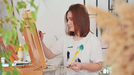 A-Red-Haired-Young-Woman-Artist-Painting-A-Frame