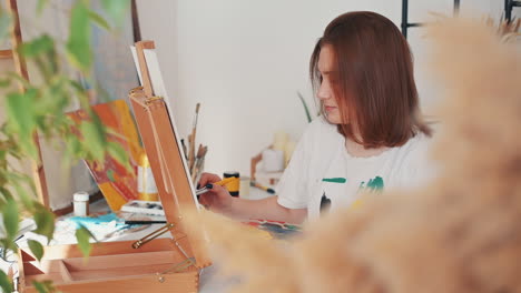 A-Red-Haired-Young-Woman-Artist-Painting-A-Frame-1