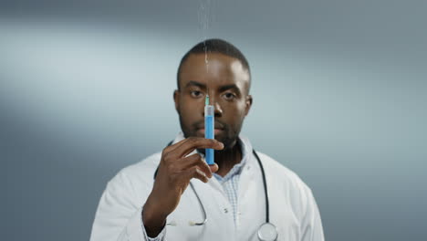 Close-Up-Of-The-Young-Man-Physician-Or-Intern-Holding-A-Syringe-With-A-Needle-And-Withdrawing-Fluid