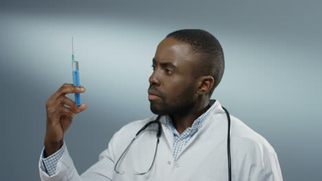 Good-Looking-Young-Male-Doctor-Or-Intern-Holding-A-Syringe-With-A-Needle-And-Withdrawing-Fluid-From-It