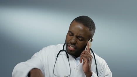 Angry-Nervous-Young-Man-Physician-Talking-And-Screaming-On-The-Phone-While-Disputing
