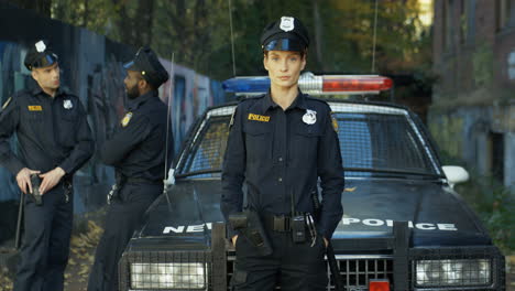 Portrait-Of-Serious-Beautiful-Policewoman-In-Uniform-And-Cap-Looking-At-Camera-Outdoors