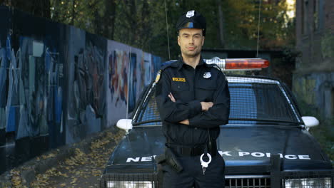 Porträt-Eines-Gutaussehenden-Polizisten-In-Uniform,-Der-Im-Freien-In-Die-Kamera-Schaut-Und-Lächelt
