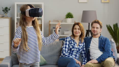 Small-Cute-Blonde-Girl-In-The-Vr-Glasses-Having-A-Vr-Headset-In-The-Living-Room