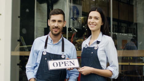 Good-Looking-Smiled-Woman-And-Man,-Workers-Of-The-Restaurant,-Standing-On-The-Street-At-The-Door-Looking-At-Each-Other-And-Then-To-The-Camera
