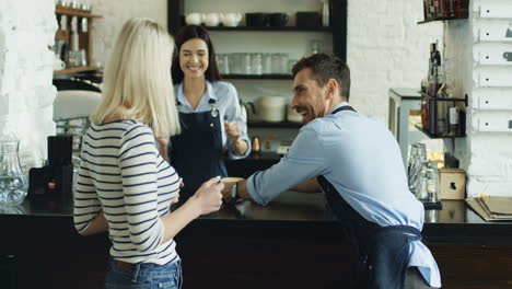 Joyful-Young-Waitress-And-Waiter-Having-Fun-And-Dancing-While-Serving-Coffee-To-The-Beautiful-Woman-At-The-Bar