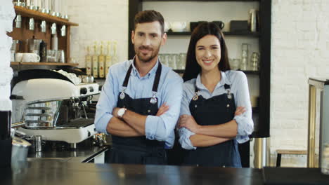 Portrait-Shot-Of-The-Attractive-Waiter-And-Waitress-Standing-Back-To-Back-At-The-Bar,-Then-Turning-And-Smiling-To-The-Camera