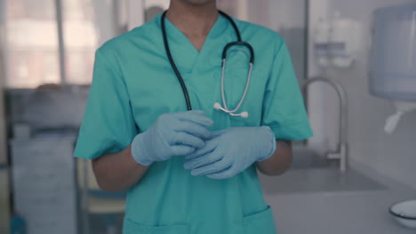 Unrecognizable-Black-Female-Doctor-Puts-On-Gloves