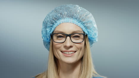Portrait-Of-The-Beautiful-Woman-Physician-In-Glasses,-Blue-Hat-Smiling-Joyfully-To-The-Camera-1